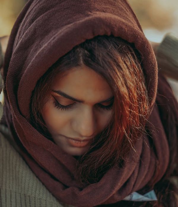 Person meditating peacefully outdoors with a calm and focused expression.