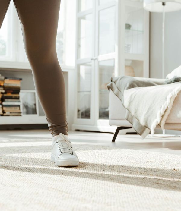 Woman feeling energetic and balanced in a bright, sunlit room.